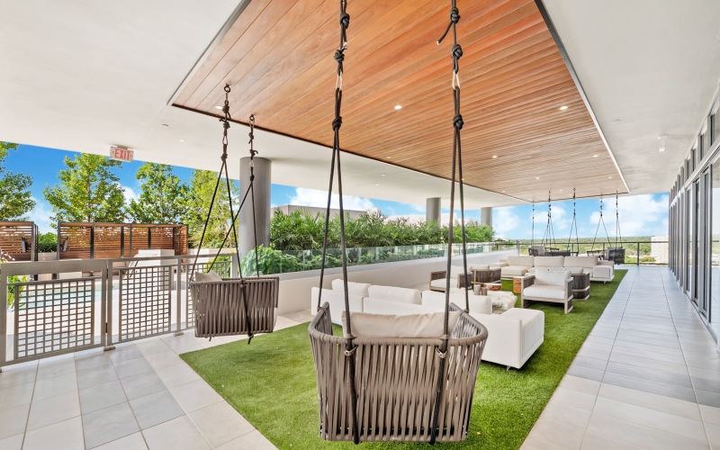 Covered outdoor seating area with dining tables and social space