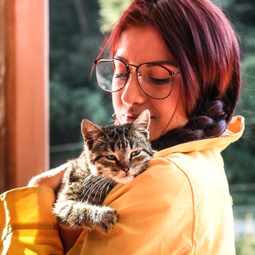Woman holding her striped tabby cat
